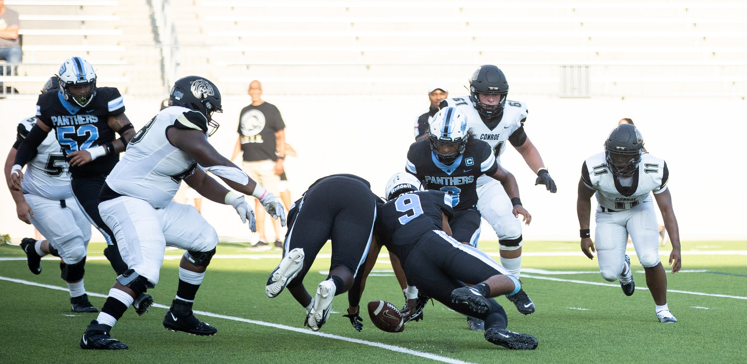 Paetow players dive on a fumble during Friday’s game against Conroe at Legacy Stadium.